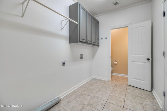 washroom with electric dryer hookup, hookup for a washing machine, ornamental molding, light tile patterned flooring, and cabinets