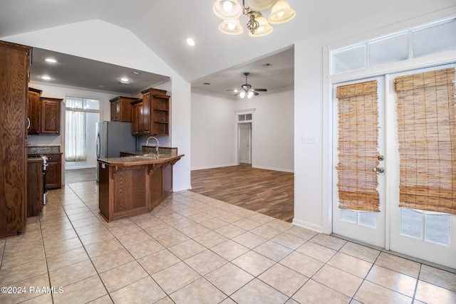 kitchen featuring a wealth of natural light, sink, ceiling fan with notable chandelier, and light tile patterned floors