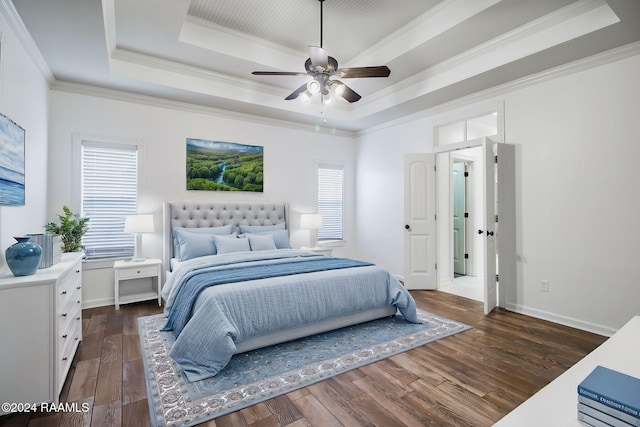 bedroom featuring crown molding, ceiling fan, dark hardwood / wood-style floors, and a raised ceiling