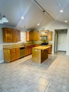 kitchen featuring light tile patterned floors, appliances with stainless steel finishes, a kitchen breakfast bar, vaulted ceiling, and a center island