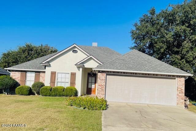 ranch-style house featuring a front yard and a garage