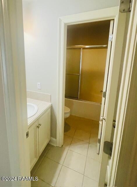 full bathroom featuring vanity, toilet, tile patterned floors, and bath / shower combo with glass door