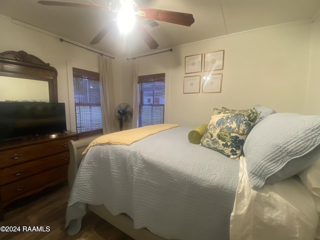 bedroom featuring dark wood-type flooring, crown molding, and ceiling fan