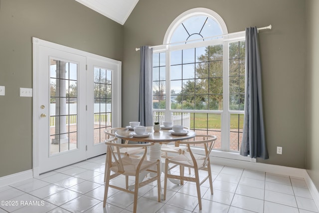 dining area with light tile patterned floors and lofted ceiling