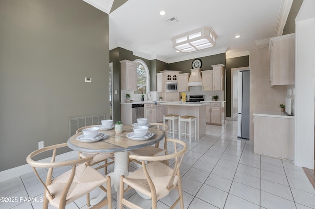 dining space featuring light tile patterned floors, sink, and ornamental molding