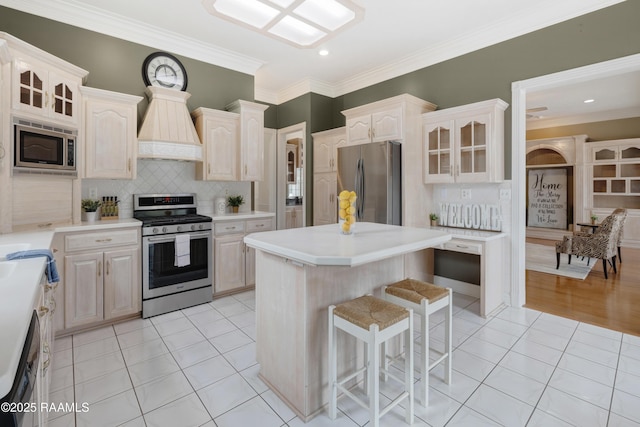 kitchen with light tile patterned floors, stainless steel appliances, a kitchen island, and premium range hood