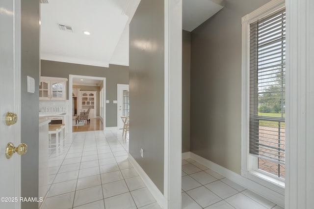 hall featuring vaulted ceiling and light tile patterned floors