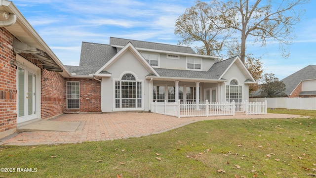 back of property featuring a lawn and a patio area