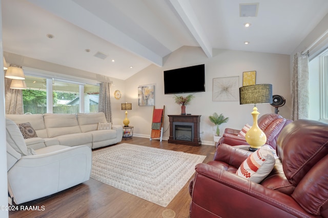 living room with lofted ceiling with beams, a wealth of natural light, and hardwood / wood-style floors