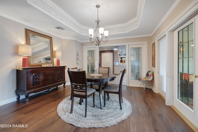 dining space with crown molding, dark hardwood / wood-style floors, a raised ceiling, a wealth of natural light, and a chandelier