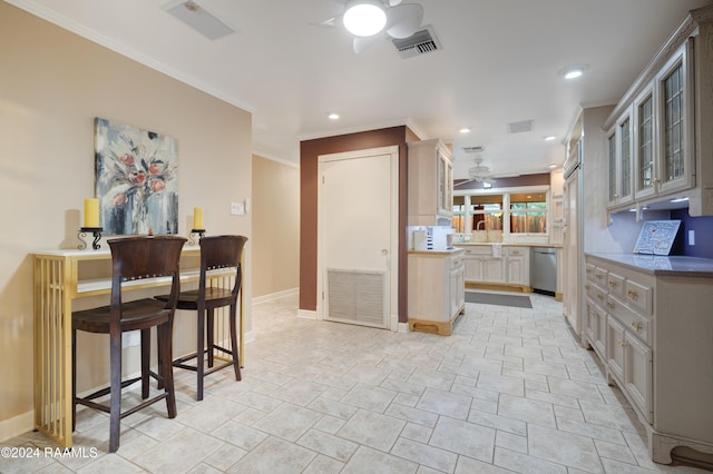 kitchen featuring stainless steel dishwasher, ceiling fan, a breakfast bar, and ornamental molding