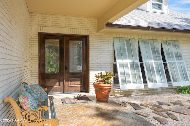 402 Old Settlement Rd, Lafayette, LA 70508 - view of exterior entry featuring brick siding, french doors, and roof with shingles
