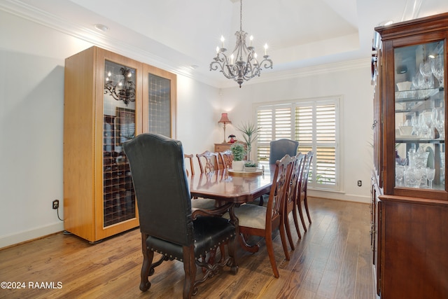 dining room featuring crown molding, wood-type flooring, and an inviting chandelier