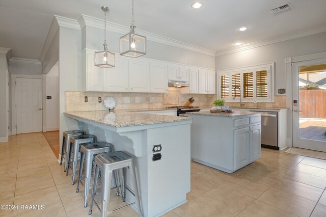 402 Old Settlement Rd, Lafayette, LA 70508 - kitchen with stainless steel appliances, under cabinet range hood, crown molding, a kitchen bar, and white cabinets
