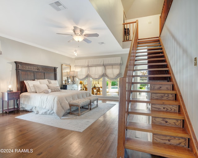 bedroom featuring dark wood-type flooring, crown molding, and ceiling fan