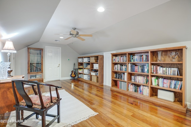 living area with ceiling fan, wood-type flooring, and vaulted ceiling