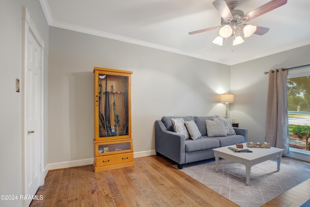 living room featuring ceiling fan, crown molding, and light wood-type flooring