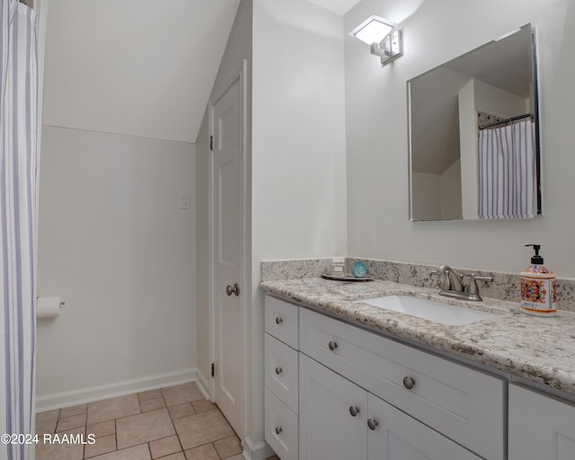 bathroom featuring vanity, tile patterned floors, and vaulted ceiling