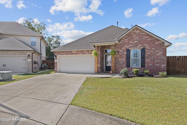 view of front property featuring cooling unit, a front yard, and a garage