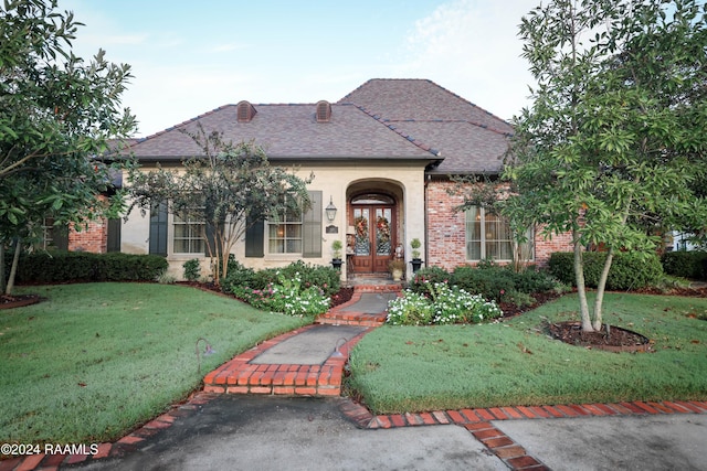 french provincial home with a front lawn