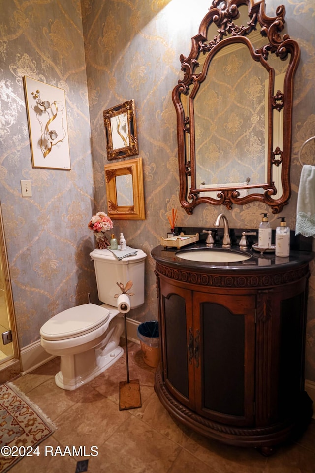 bathroom featuring wallpapered walls, baseboards, toilet, and vanity