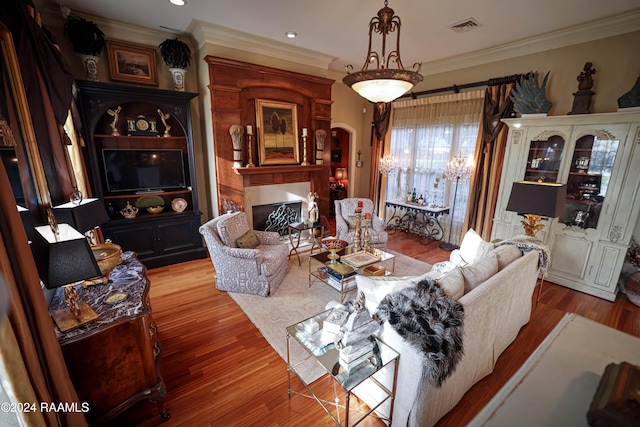 living room with hardwood / wood-style flooring and ornamental molding