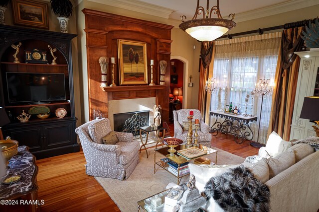 living room with ornamental molding, wood finished floors, a fireplace, and arched walkways
