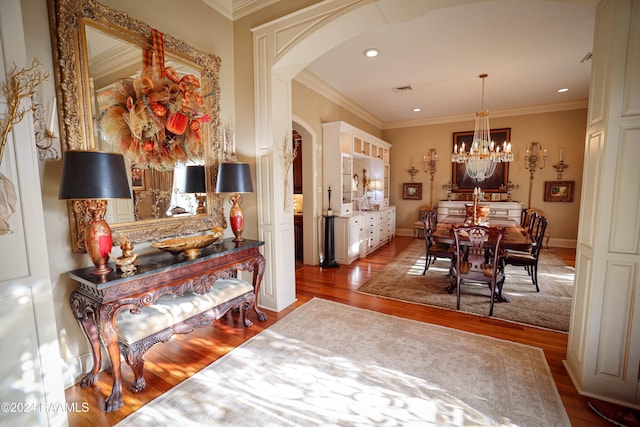 dining room featuring arched walkways, dark wood-style floors, crown molding, a chandelier, and recessed lighting
