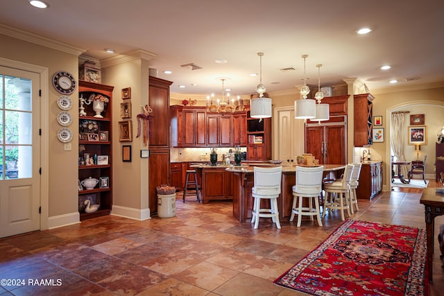 kitchen with a kitchen island, a kitchen breakfast bar, hanging light fixtures, ornamental molding, and a notable chandelier