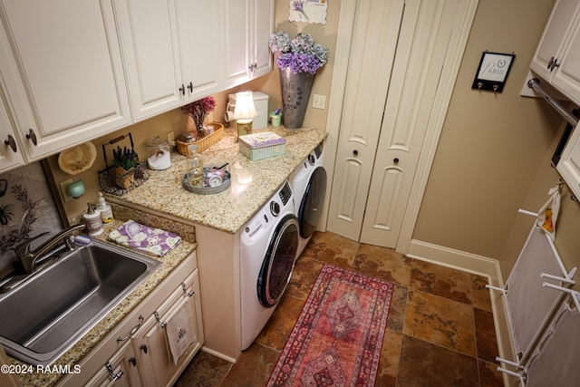washroom featuring independent washer and dryer, dark stone finish flooring, baseboards, and cabinet space
