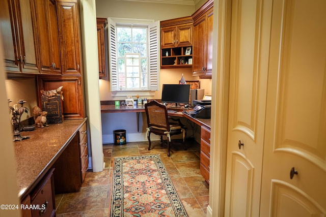 home office featuring built in desk and light stone finish flooring