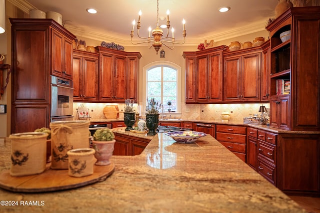 kitchen with tasteful backsplash, light stone countertops, pendant lighting, crown molding, and a chandelier