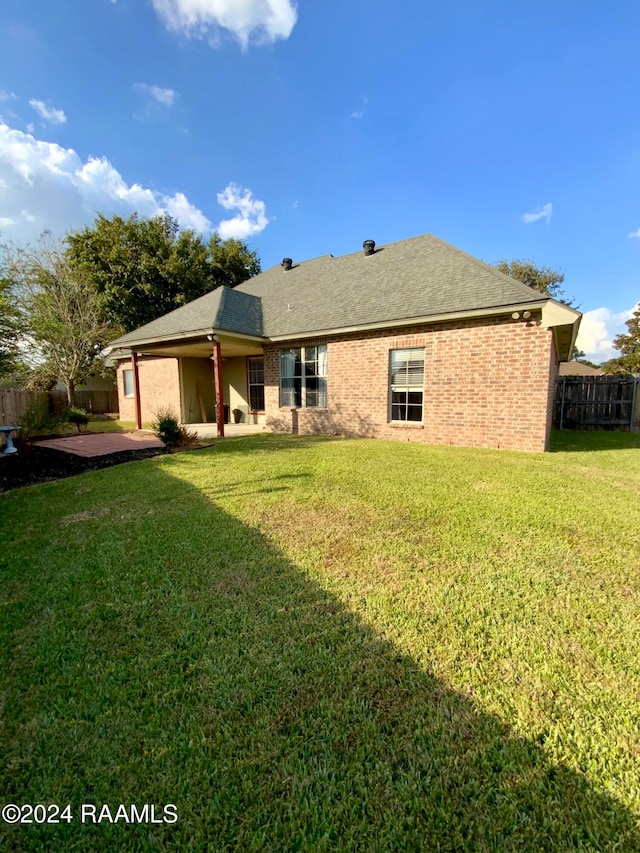 rear view of house featuring a patio area and a lawn