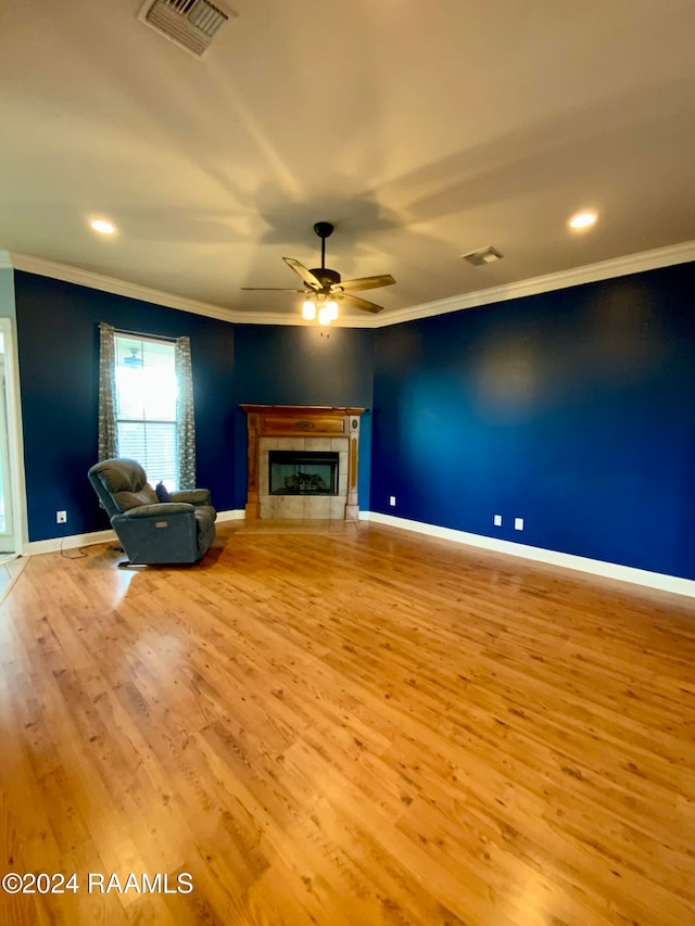 unfurnished living room with crown molding, light hardwood / wood-style flooring, a fireplace, and ceiling fan