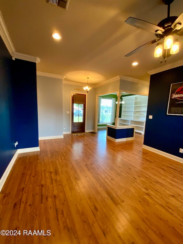 unfurnished living room with light hardwood / wood-style flooring, ornamental molding, and ceiling fan with notable chandelier