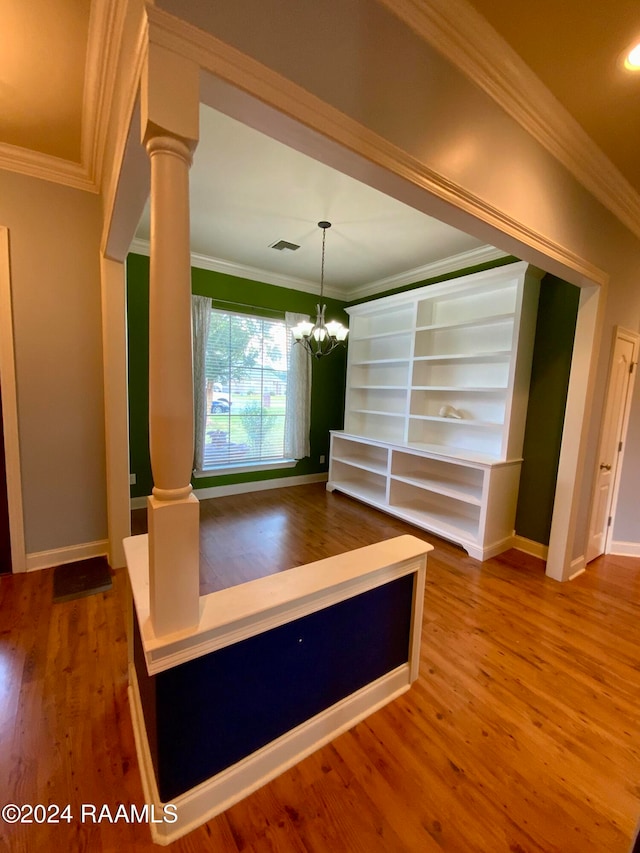 unfurnished dining area with ornamental molding, wood-type flooring, and ornate columns