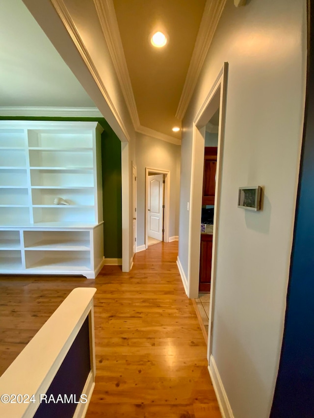 hall with light hardwood / wood-style floors and ornamental molding