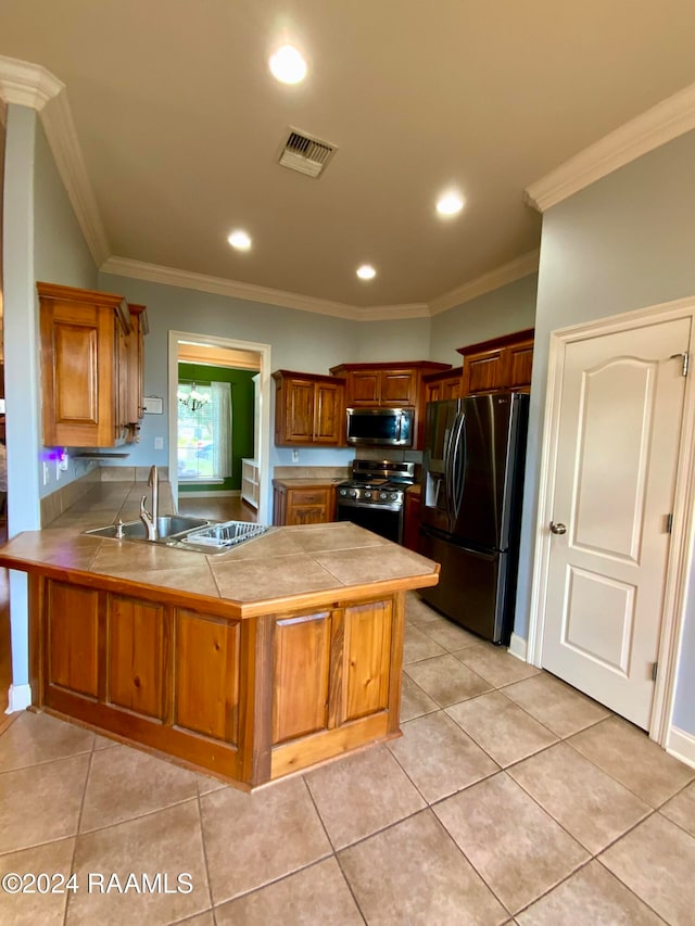 kitchen with tile counters, kitchen peninsula, ornamental molding, sink, and appliances with stainless steel finishes