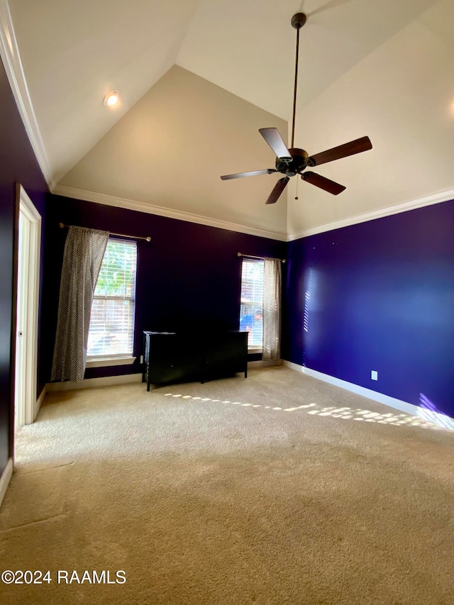 carpeted empty room with crown molding, vaulted ceiling, plenty of natural light, and ceiling fan