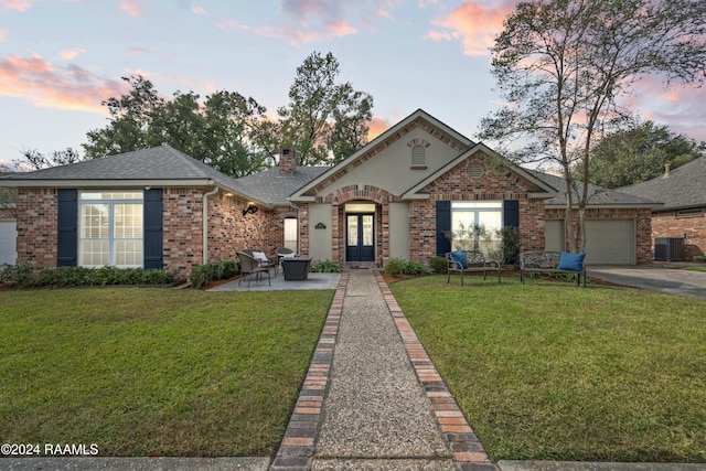 view of front of house featuring a patio area, a garage, and a lawn