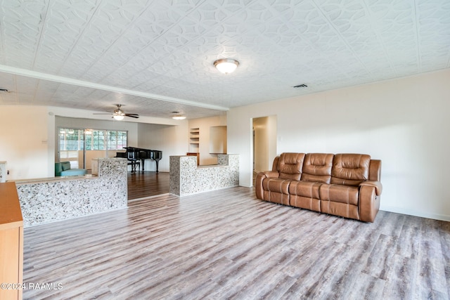 living room featuring light hardwood / wood-style floors, a textured ceiling, and ceiling fan