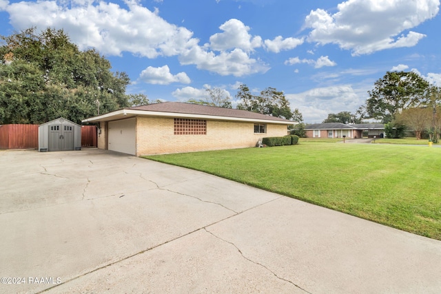 view of side of property with a garage, a storage shed, and a lawn