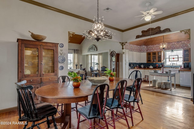 dining space featuring light wood-type flooring, ceiling fan with notable chandelier, and crown molding