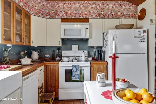 kitchen featuring white appliances, hardwood / wood-style floors, and white cabinets