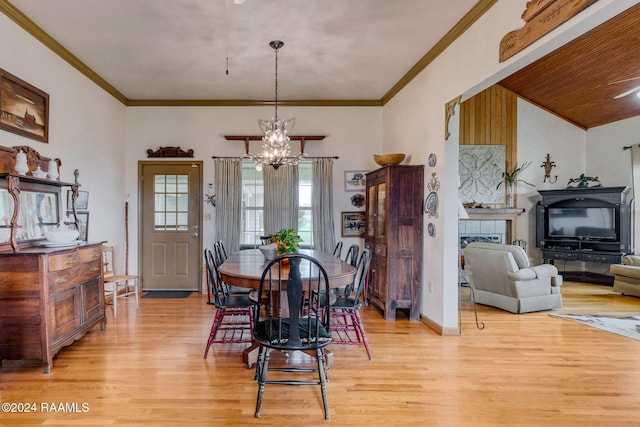 dining space featuring an inviting chandelier, ornamental molding, and light hardwood / wood-style flooring