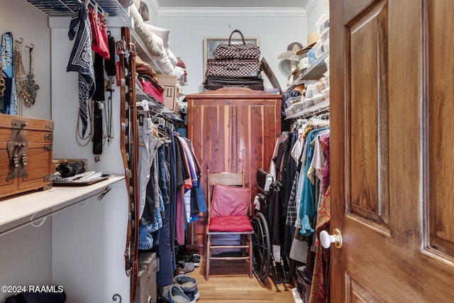 walk in closet with light hardwood / wood-style floors