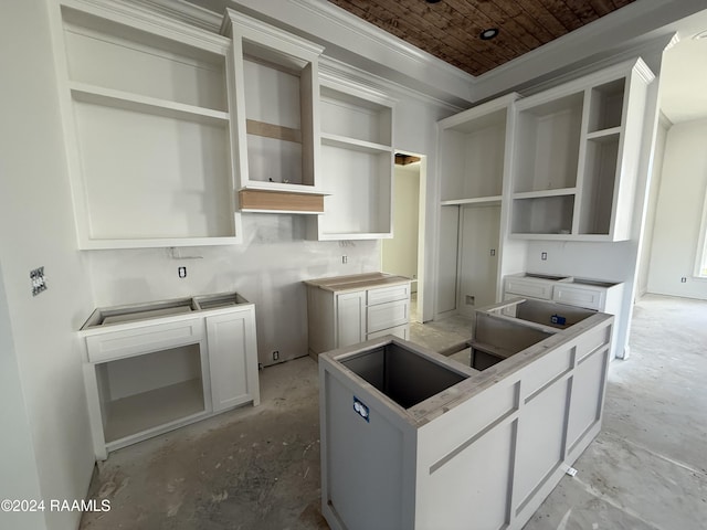 kitchen with white cabinets, ornamental molding, and wood ceiling