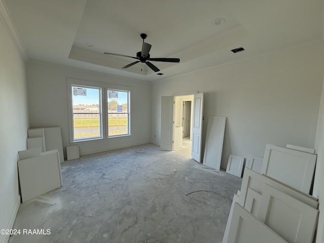 spare room featuring ceiling fan, a raised ceiling, and crown molding