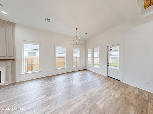 unfurnished living room featuring plenty of natural light, a fireplace, visible vents, and crown molding