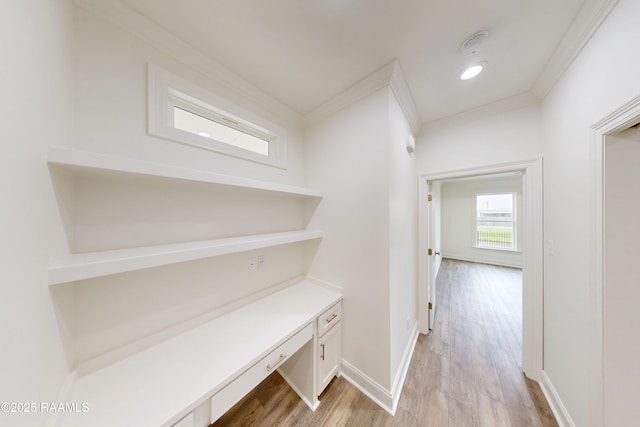 hallway with light wood-style floors, recessed lighting, crown molding, and baseboards